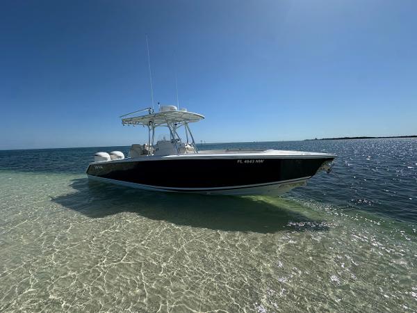 Jupiter 29 Cc 2009 Jupiter 29 FS CC boat anchored on clear, shallow water under a bright blue sky.