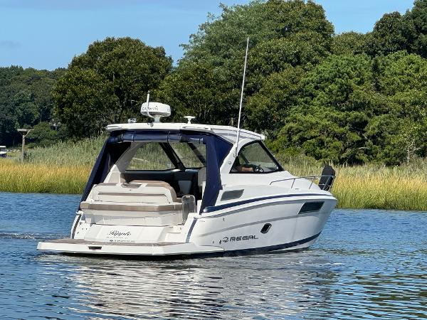 Regal 35 Sport Coupe 2016 Regal 35 Sport Coupe cruising on a serene lake with lush greenery.