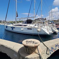 Jeanneau 53 2015 Jeanneau 53 sailboat docked in a marina under a clear blue sky.