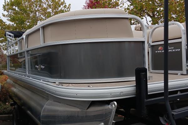 Sun Tracker Party Barge 18 DLX 2025 Sun Tracker Party Barge 18 DLX pontoon boat, docked outdoors.