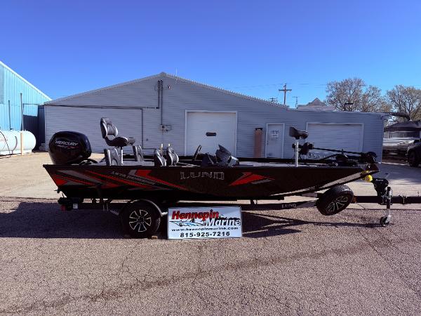 Lund 1875 Renegade SS 2025 Lund 1875 Renegade SS fishing boat on trailer, parked outside a marine dealership.