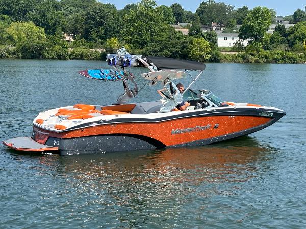MasterCraft X23 2015 MasterCraft X23 boat on a lake with wakeboards.