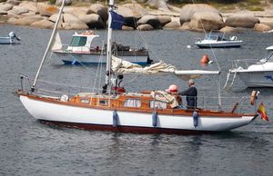 Custom One Design 1969 sailboat in harbor with Spanish flag.
