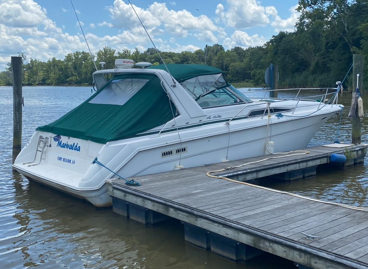 Sea Ray 370 Sundancer 1993 Sea Ray 370 Sundancer docked by a scenic river under a cloudy sky.