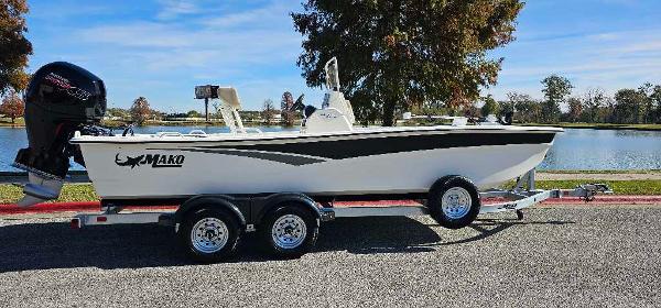 Mako Pro Skiff 19 CC 2024 Mako Pro Skiff 19 CC boat on trailer by a lake.