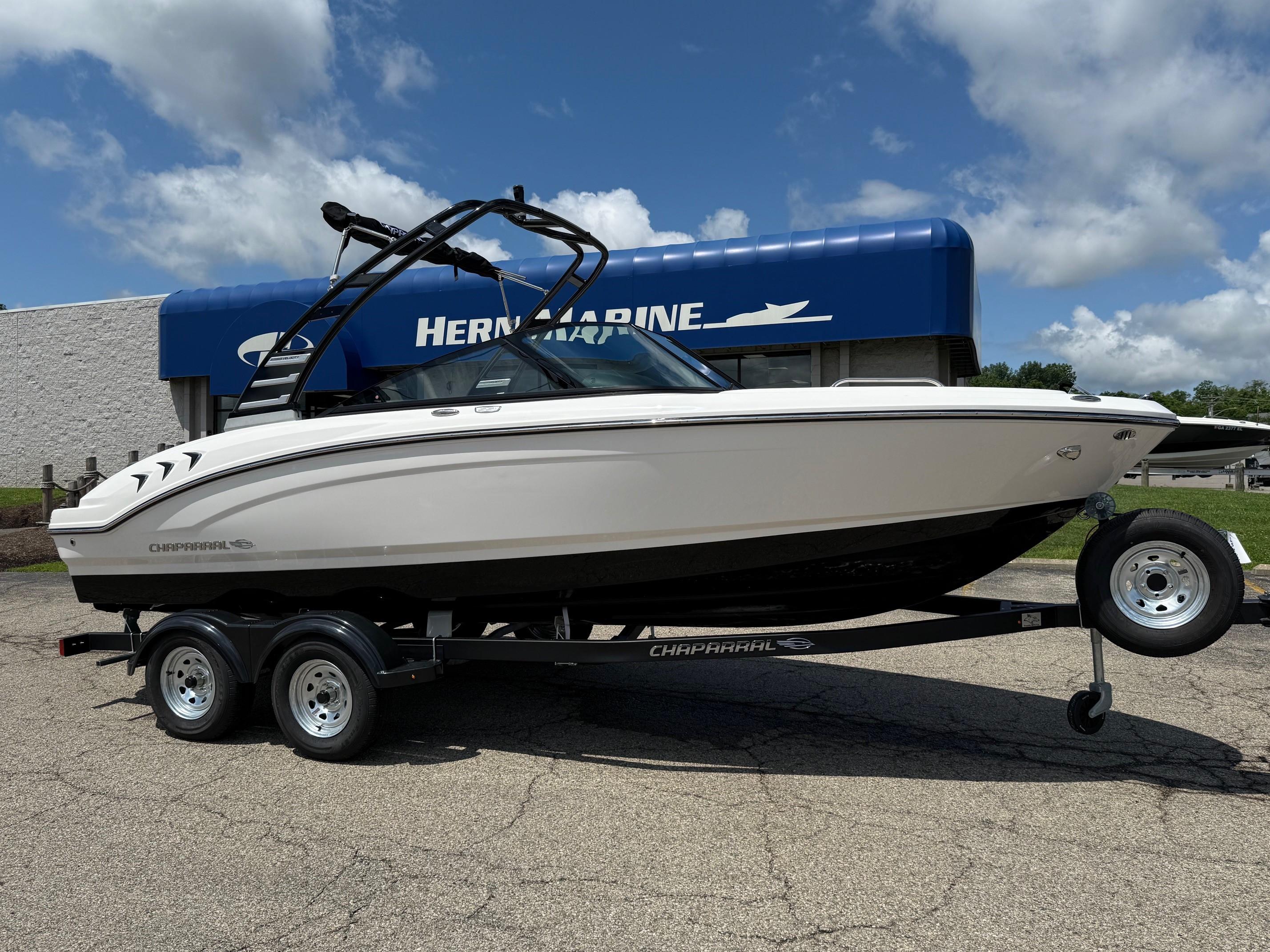 Chaparral 21 SSi 2025 Chaparral 21 SSi boat on trailer, displayed outdoors at Hern Marine dealership.