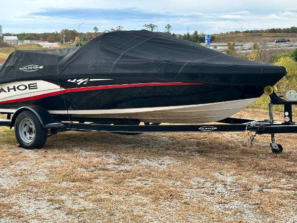 Tahoe Q4i 2013 Tahoe Q4i boat on trailer with black cover, parked outdoors.