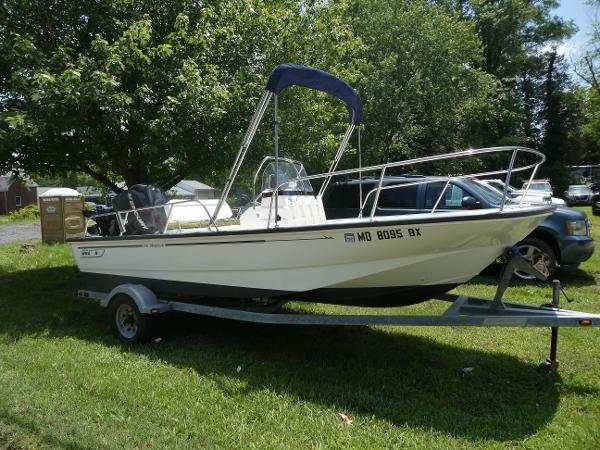 Boston Whaler 170 Montauk 2007 Boston Whaler 170 Montauk boat on trailer, parked on grass.