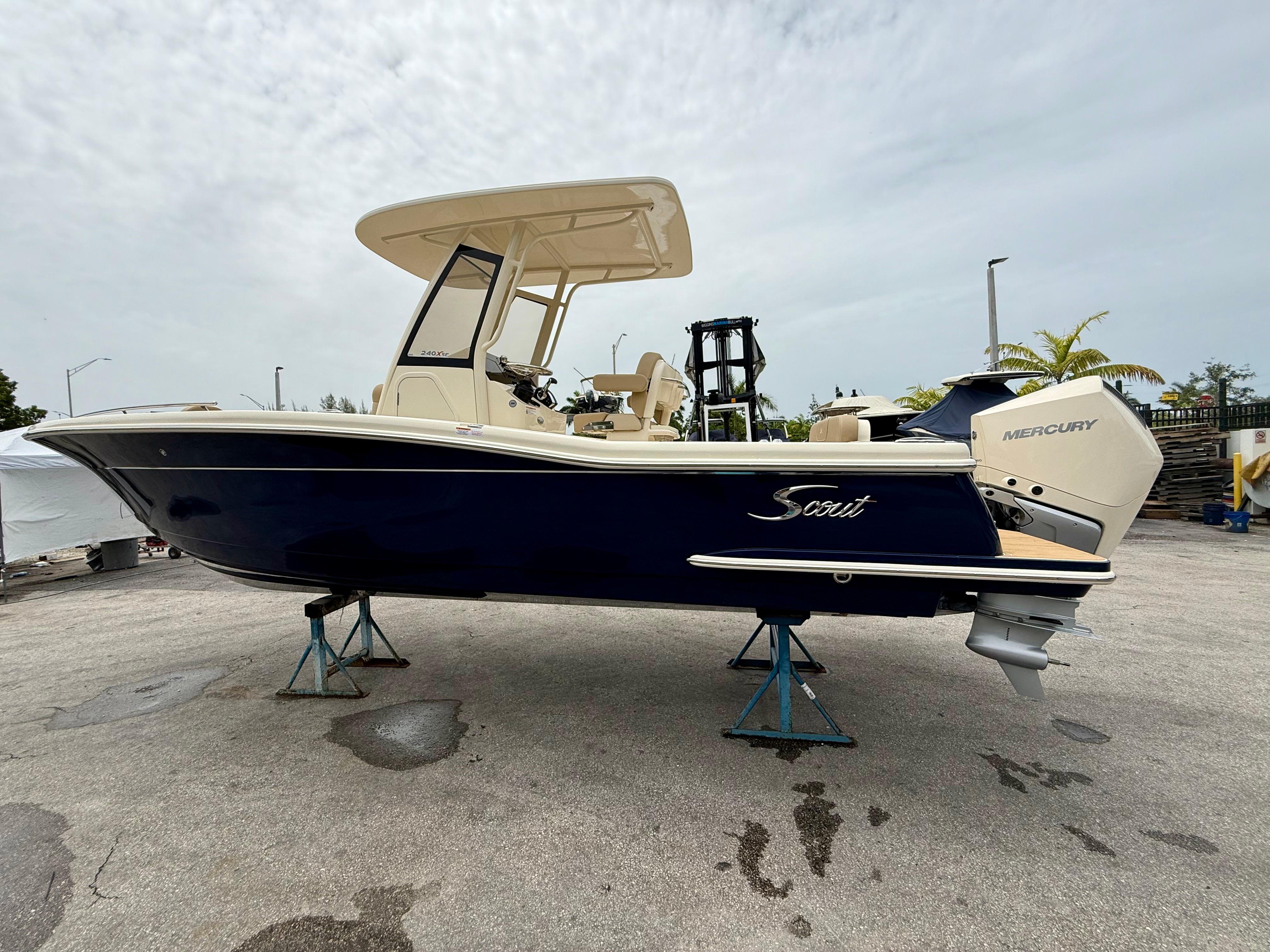 Scout 240 XSF 2026 Scout 240 XSF boat with Mercury engine on display outdoors.