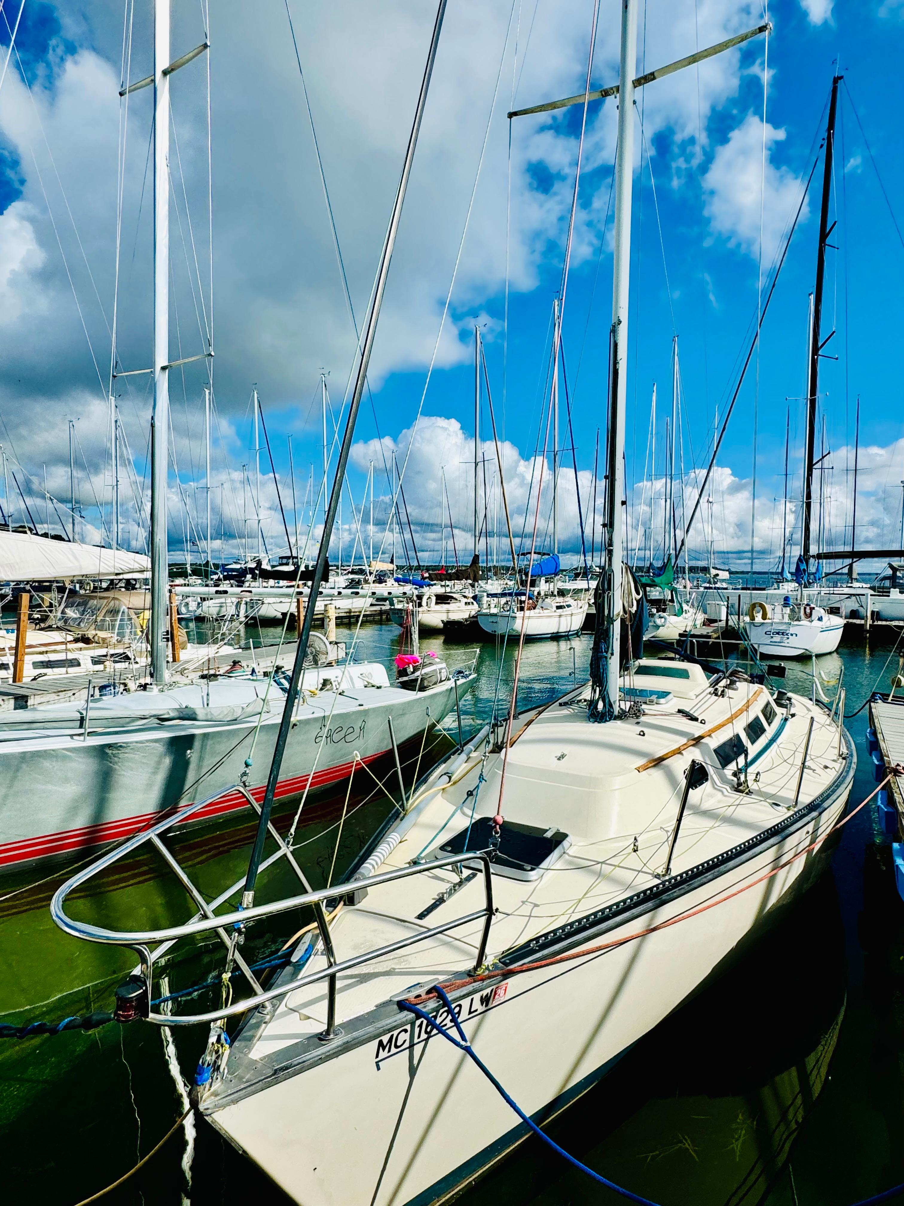 S2 9.1 Sailboats docked at marina under cloudy sky, featuring 1985 S2 9.1 model.