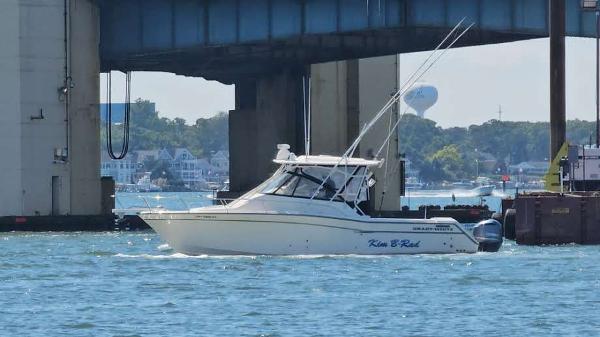 Grady-White Express 330 2016 Grady-White Express 330 boat cruising under a bridge on a sunny day.