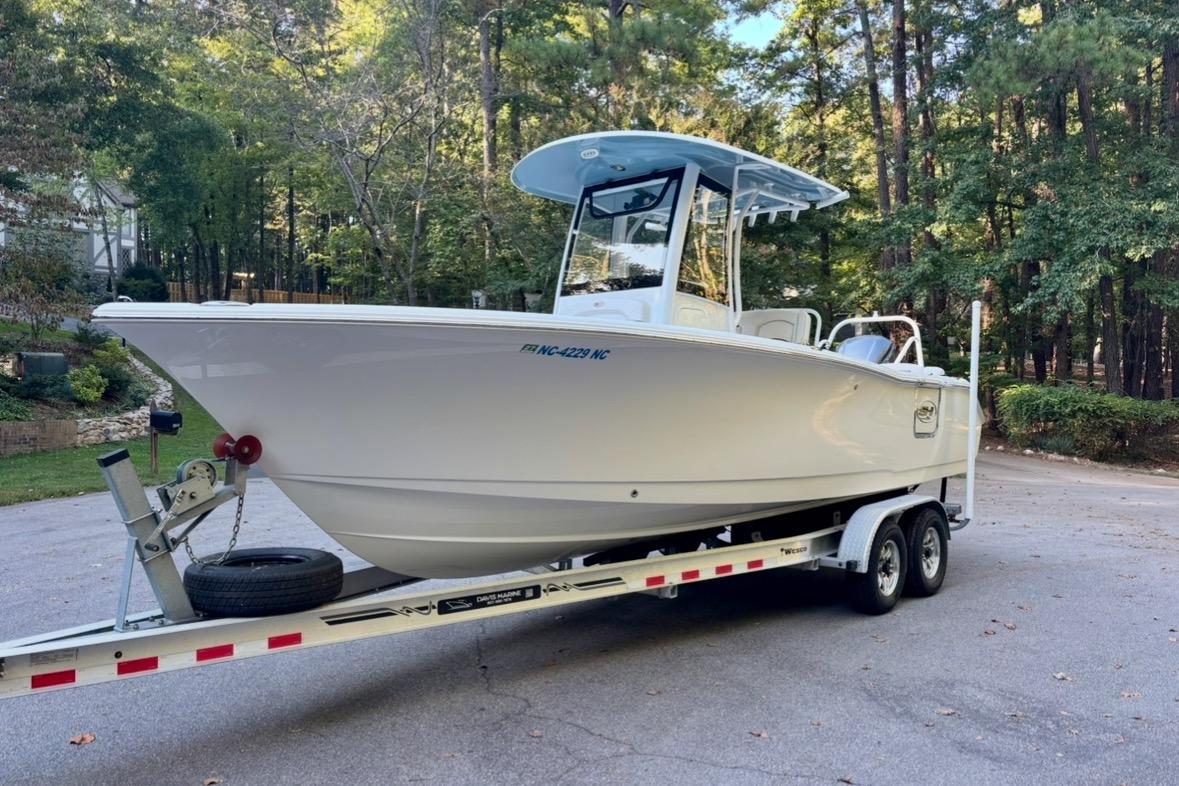 Sea Hunt Ultra 255 SE 2021 Sea Hunt Ultra 255 SE boat on trailer, surrounded by trees.