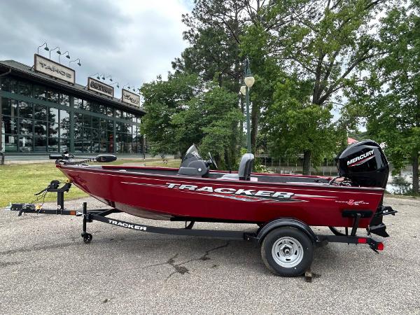 Tracker Super Guide V-16 SC 2025 Tracker Super Guide V-16 SC boat on trailer, parked outdoors near trees.