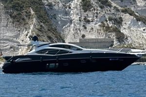 Sunseeker Predator 64 2009 Sunseeker Predator 64 yacht cruising near rocky cliffs.