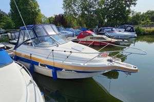 Maxum 2400 SCR 1998 Maxum 2400 SCR boat for sale, docked in a marina, surrounded by trees.