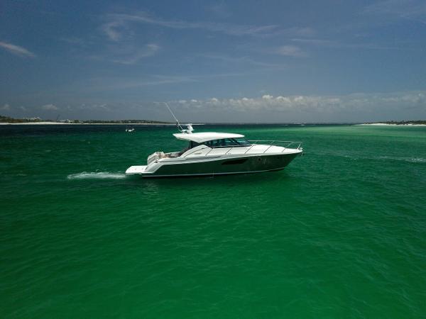 Tiara Yachts C44 Coupe 2015 Tiara Yachts 44 Coupe cruising on vibrant turquoise waters under a clear sky.