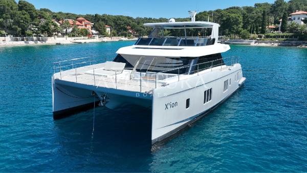 Sunreef 60 Power Luxury Sunreef 60 Power catamaran, 2021 model, anchored in clear blue waters.