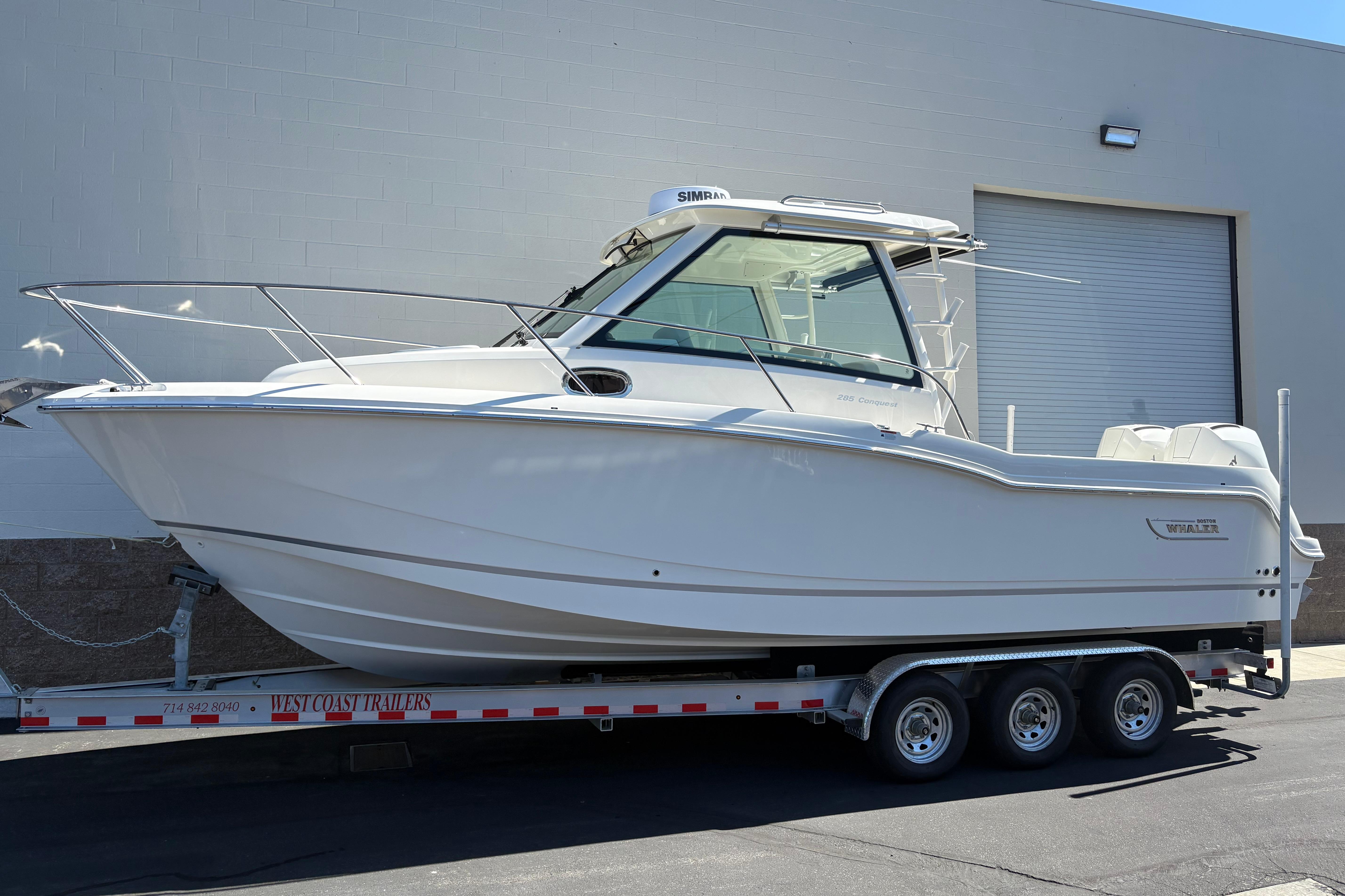 Boston Whaler 285 Conquest 2026 Boston Whaler 285 Conquest boat on trailer, parked outside a building.