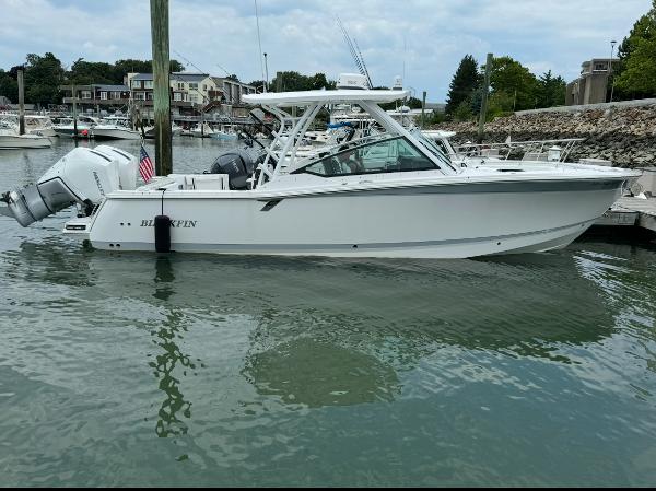 Blackfin 302 DC 2024 Blackfin 302 DC boat docked in a marina, featuring sleek design and dual engines.