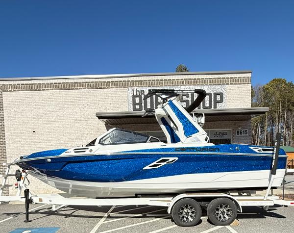 Centurion Ri230 2025 Centurion Ri230 boat in blue and white on a trailer outside a brick building.