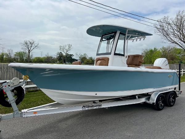 Sea Hunt Ultra 235SE 2025 Sea Hunt Ultra 235SE boat on trailer, blue hull, parked on roadside.
