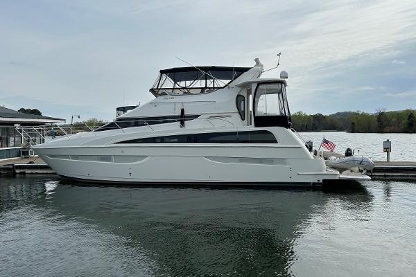 Carver 43 Motor Yacht 2006 Carver 43 Motor Yacht docked on a calm lake under a cloudy sky.
