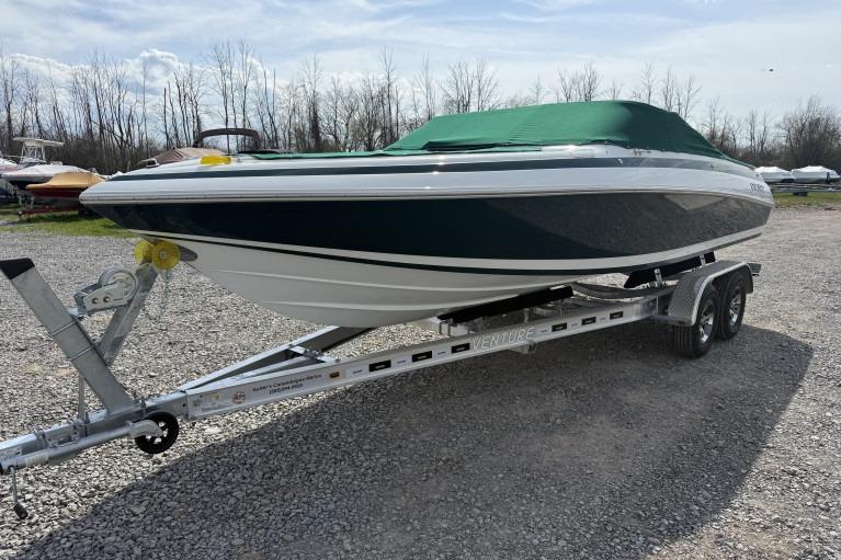 Cobalt 220 1998 Cobalt 220 boat on trailer with green cover, parked on gravel.