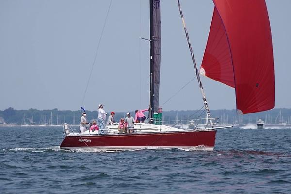 C&C 99 Red C&C 99 sailboat from 2002 with crew, sailing on open water.
