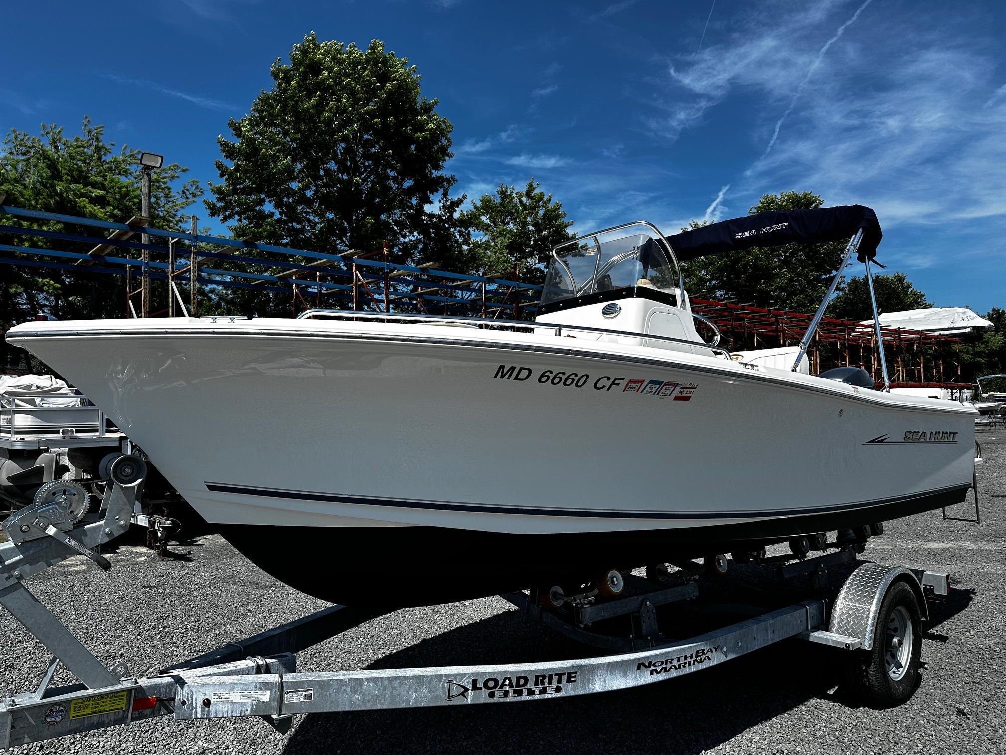 Sea Hunt Triton 202 Center Console 2013 Sea Hunt Triton 202 Center Console boat on trailer, parked outdoors.