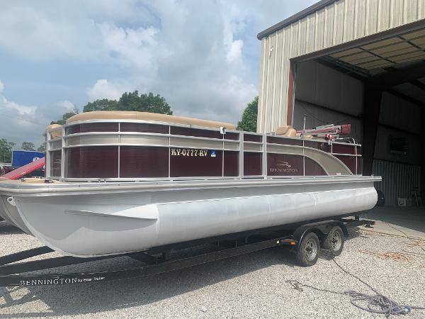 Bennington 24 SCWX-EXP 2016 Bennington 24 SCWX-EXP pontoon boat on trailer near a storage building.