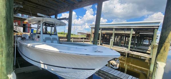 Regulator 31 FS 2021 Regulator 31 FS boat docked under a wooden shelter on a sunny day.
