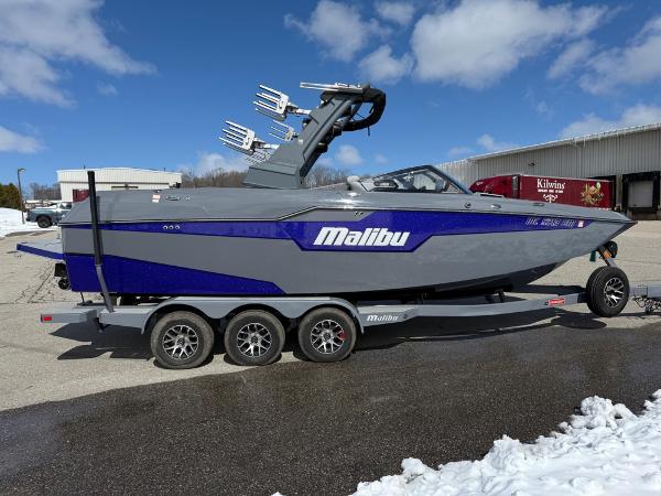 Malibu M240 2021 Malibu M240 boat on trailer, gray and blue design, parked outdoors.