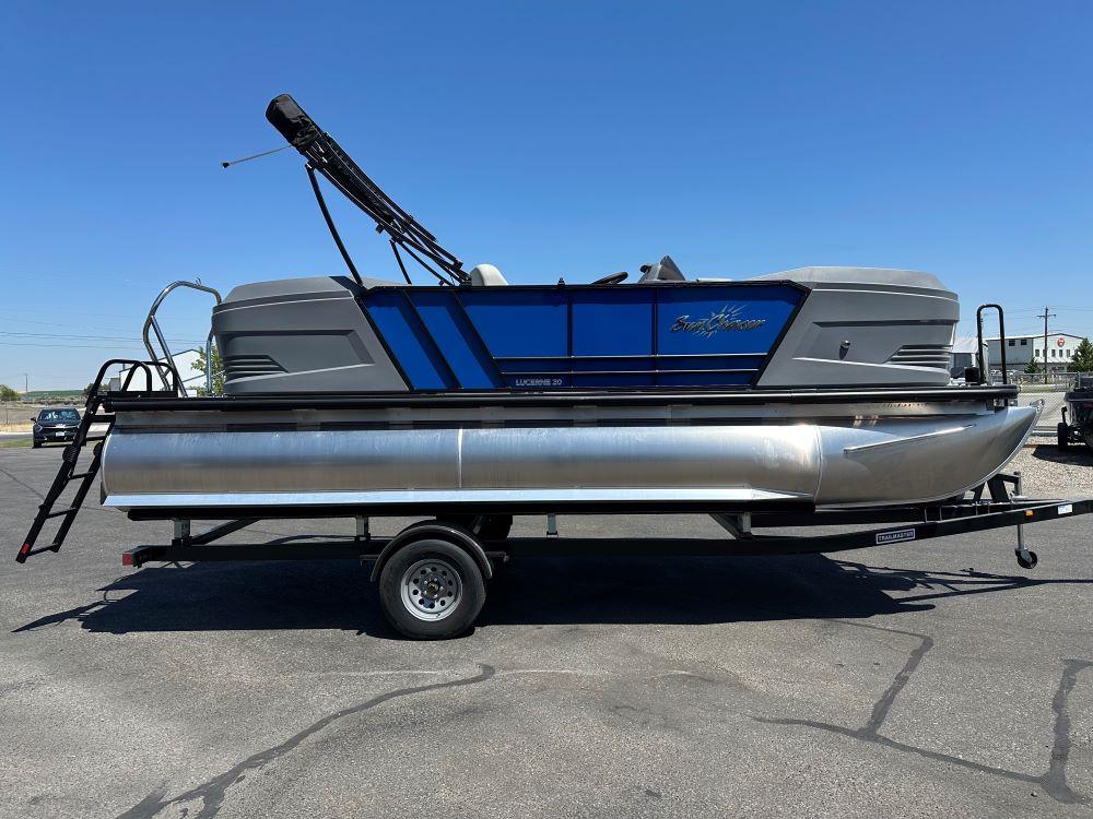 SunChaser Lucerne 20 LR DH 2026 SunChaser Lucerne 20 LR DH pontoon boat on trailer, under clear blue sky.