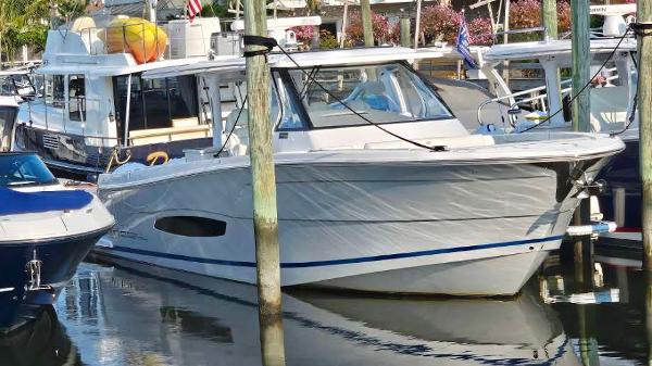 Regal 38 SAV 2021 Regal 38 SAV boat docked in a marina, surrounded by other vessels.
