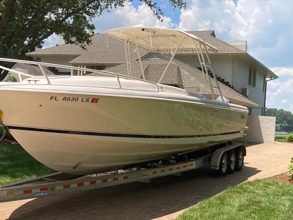 Intrepid 322 2002 Intrepid 322 boat on a trailer in front of a house.