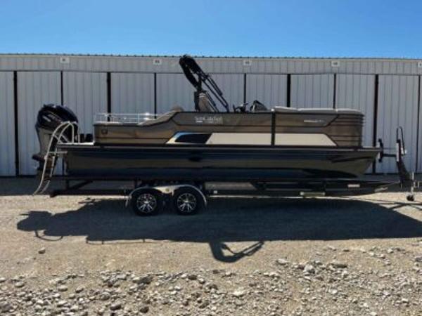 SunCatcher Elite 324 SS 2025 SunCatcher Elite 324 SS pontoon boat on trailer, parked outdoors.