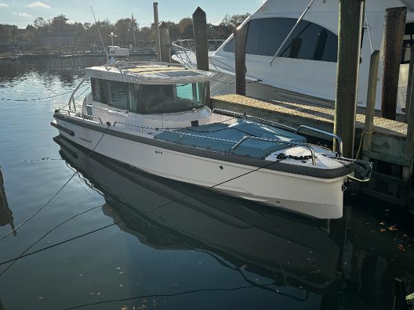 Axopar 28 CABIN 2023 Axopar 28 CABIN boat docked in a serene marina setting.
