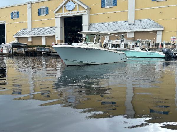 Sailfish 272 CC 2023 Sailfish 272 CC boat docked near a yellow building with blue shutters.