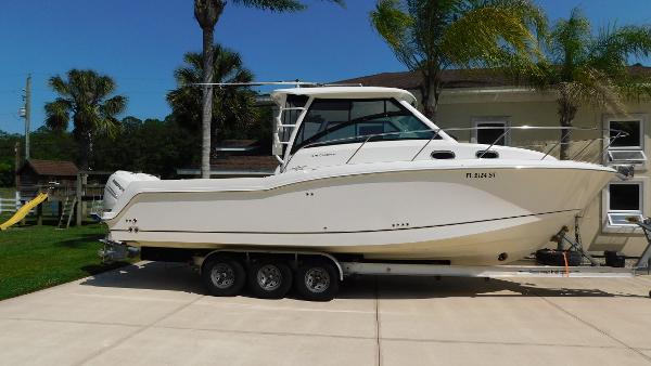 Boston Whaler 315 Conquest 2017 Boston Whaler 315 Conquest boat on trailer, parked in driveway with palm trees.