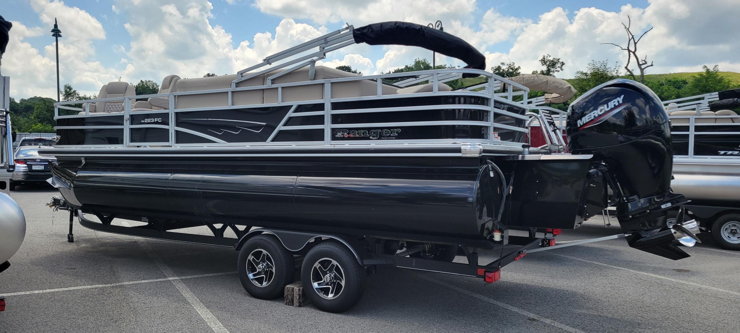 Ranger Reata 223FC 2024 Ranger Reata 223FC pontoon boat with Mercury engine, parked on a trailer.