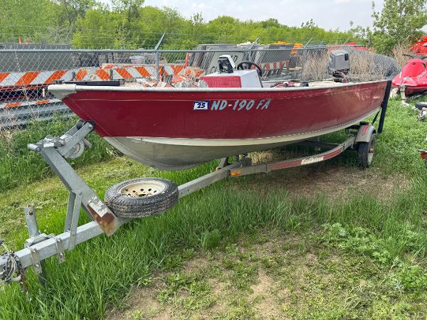 Alumacraft SC 1994 Alumacraft SC boat on trailer, red exterior, parked on grass.