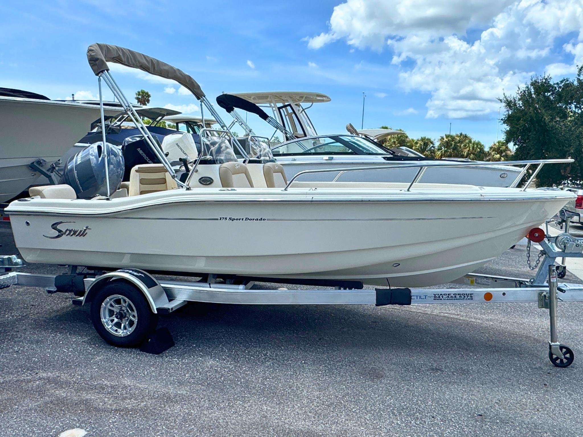 Scout 175 Sport Dorado 2024 Scout 175 Sport Dorado boat on trailer, parked outdoors under a blue sky.