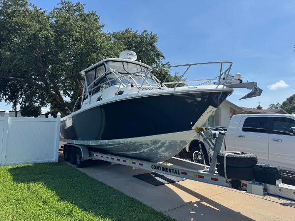 Sailfish 30-06 Express 2008 Sailfish 30-06 Express boat on trailer, parked in driveway under clear blue sky.