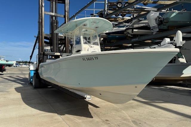 Cobia 240 Center Console 2022 Cobia 240 Center Console boat on a forklift at a marina.