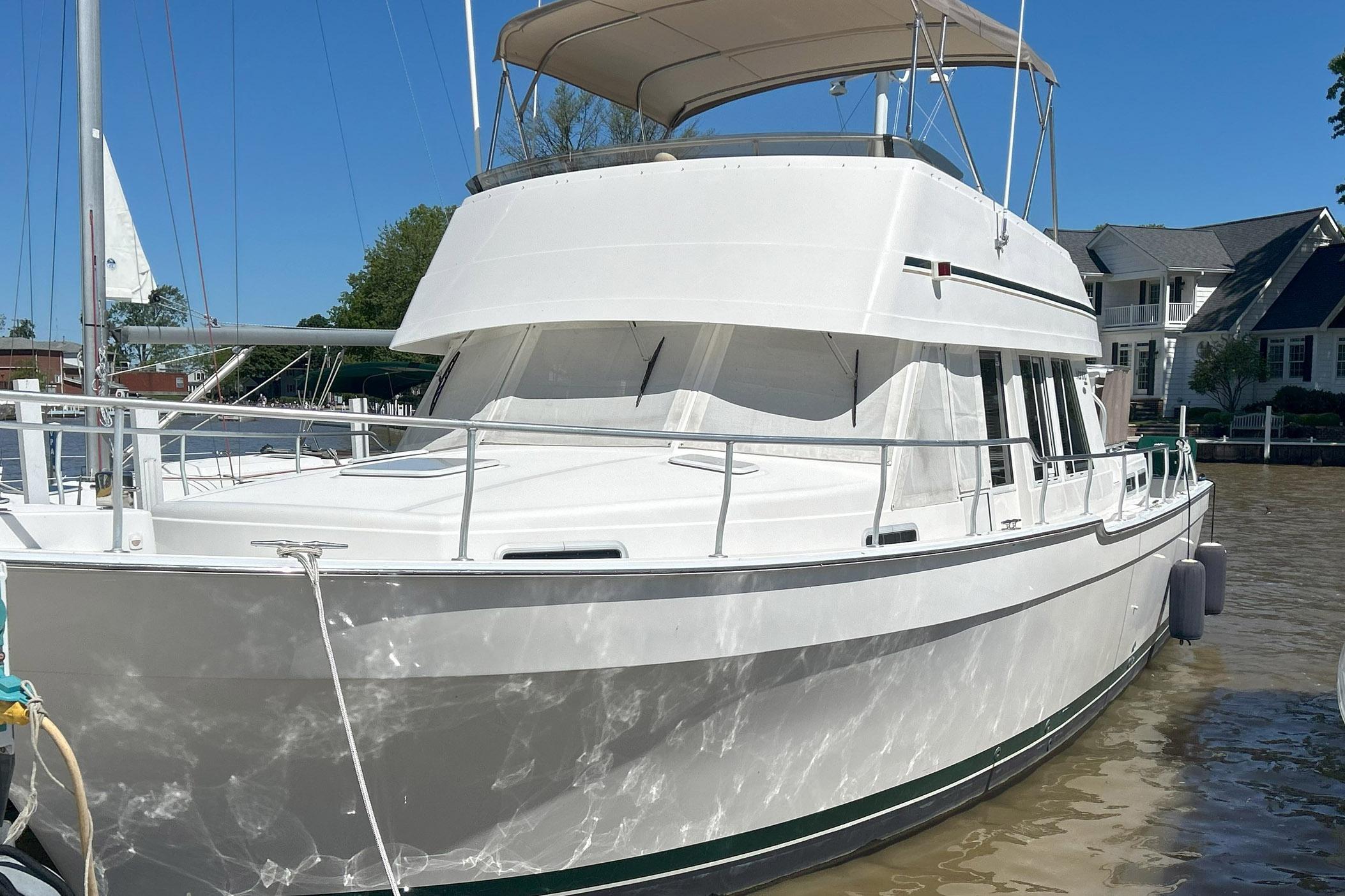 Mainship 430 Trawler 2002 Mainship 430 Trawler docked, featuring a white exterior and spacious deck.