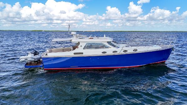 Custom 48 Gentlemans Custom 48 yacht, 2010 model, cruising on open water under a blue sky.