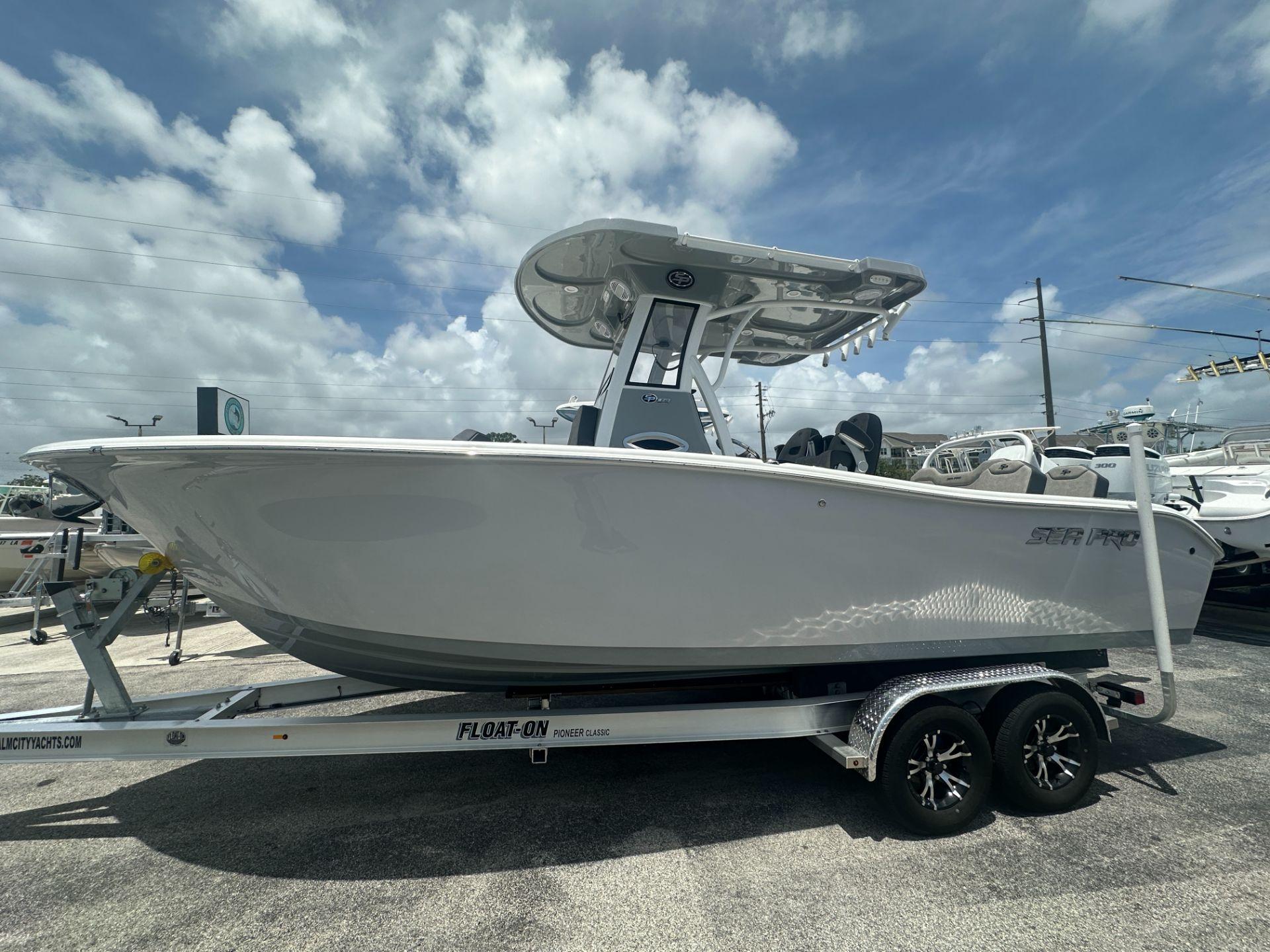 Sea Pro 245 FLX 2025 Sea Pro 245 FLX boat on trailer under a partly cloudy sky.