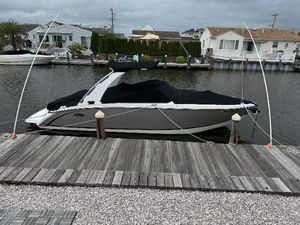 Cobalt R7 2015 Cobalt R7 boat docked by waterfront homes under cloudy skies.