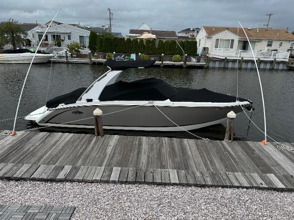 Cobalt R7 2015 Cobalt R7 boat docked by waterfront homes under cloudy skies.