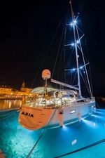 Jeanneau 64 Luxurious 2016 Jeanneau 64 yacht illuminated at night in a serene harbor.